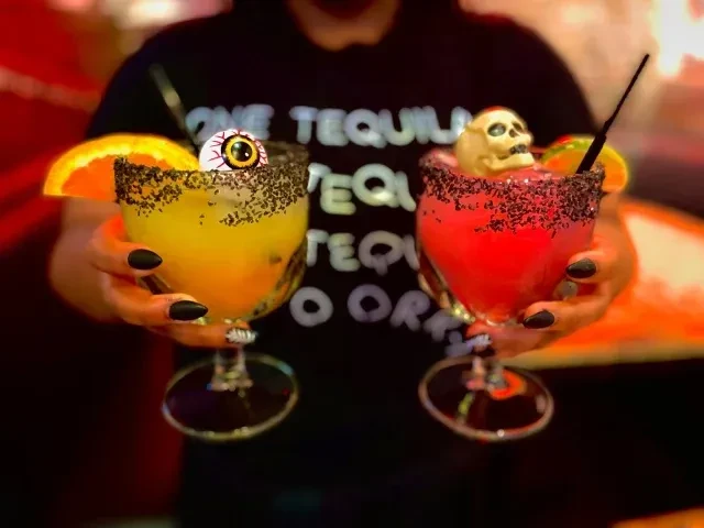 Two Halloween cocktails, one with an eyeball, the other with a skull.