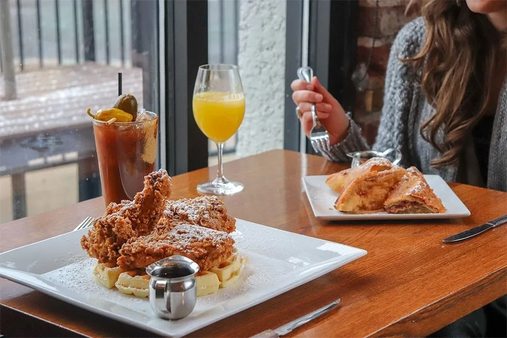 Fried chicken and waffles, French toast, Bloody Mary, and orange juice.