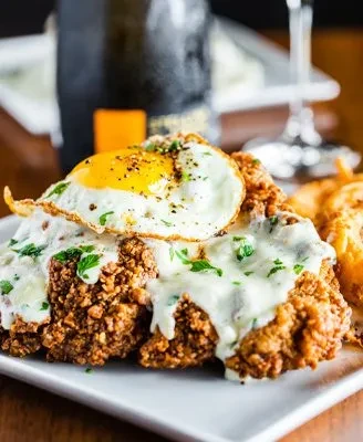 Chicken fried steak with a fried egg, gravy, and black pepper.
