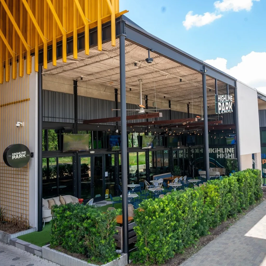 Exterior of Highline Park building with yellow overhang and outdoor patio.