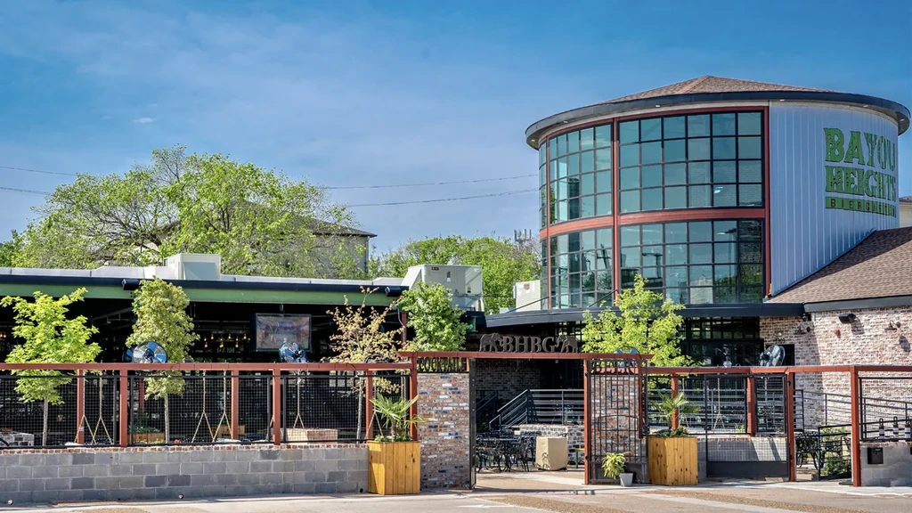 Exterior of Bayou Heights Biergarten building with patio on a sunny day.
