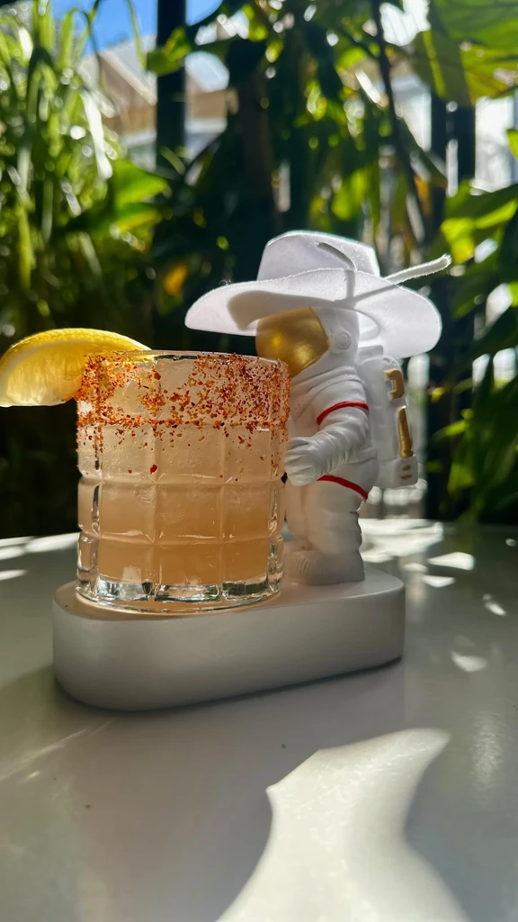 Spiced drink with lemon and an astronaut figurine with a cowboy hat.