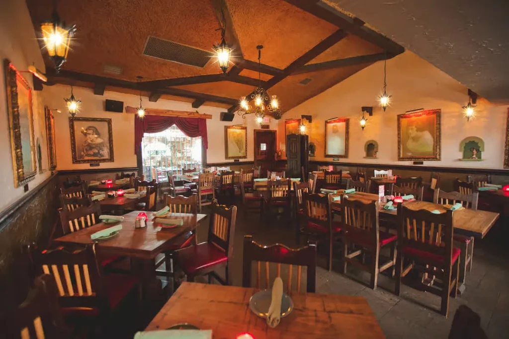 Rustic restaurant interior with wooden tables, chairs, and star-shaped lanterns.