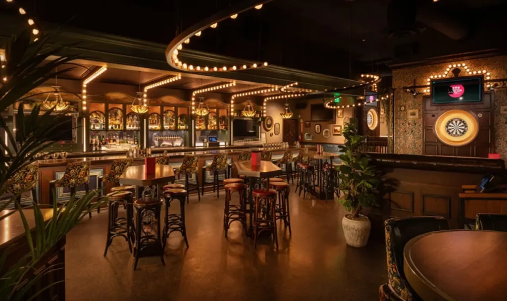 Dimly lit bar interior with a long counter and vintage decor.
