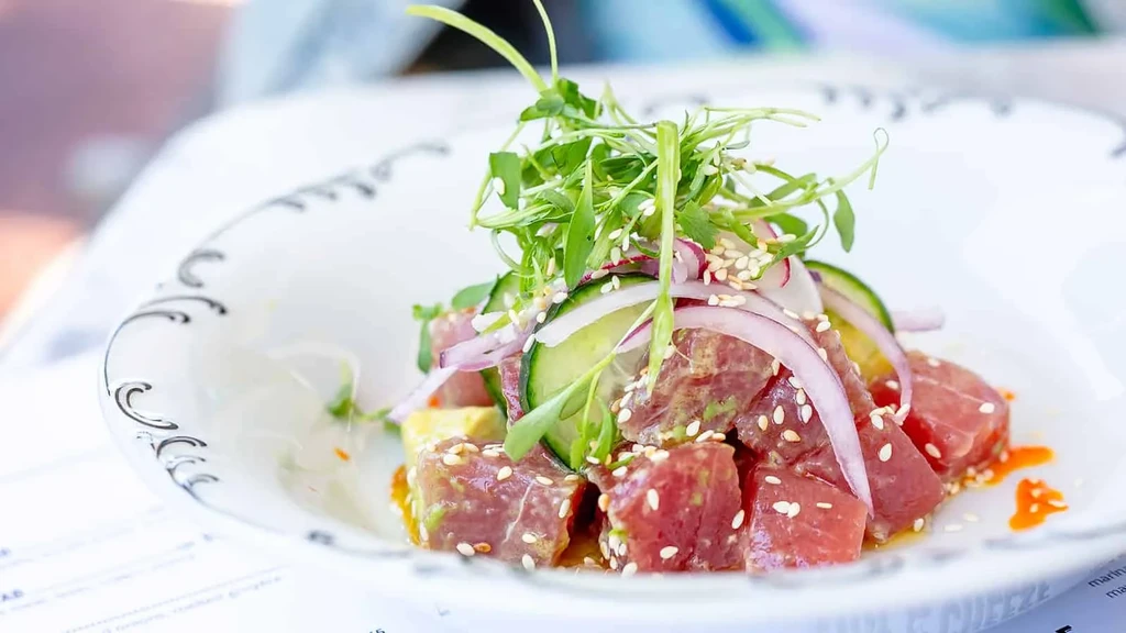 Poke bowl with tuna, cucumbers, red onions, and microgreens.