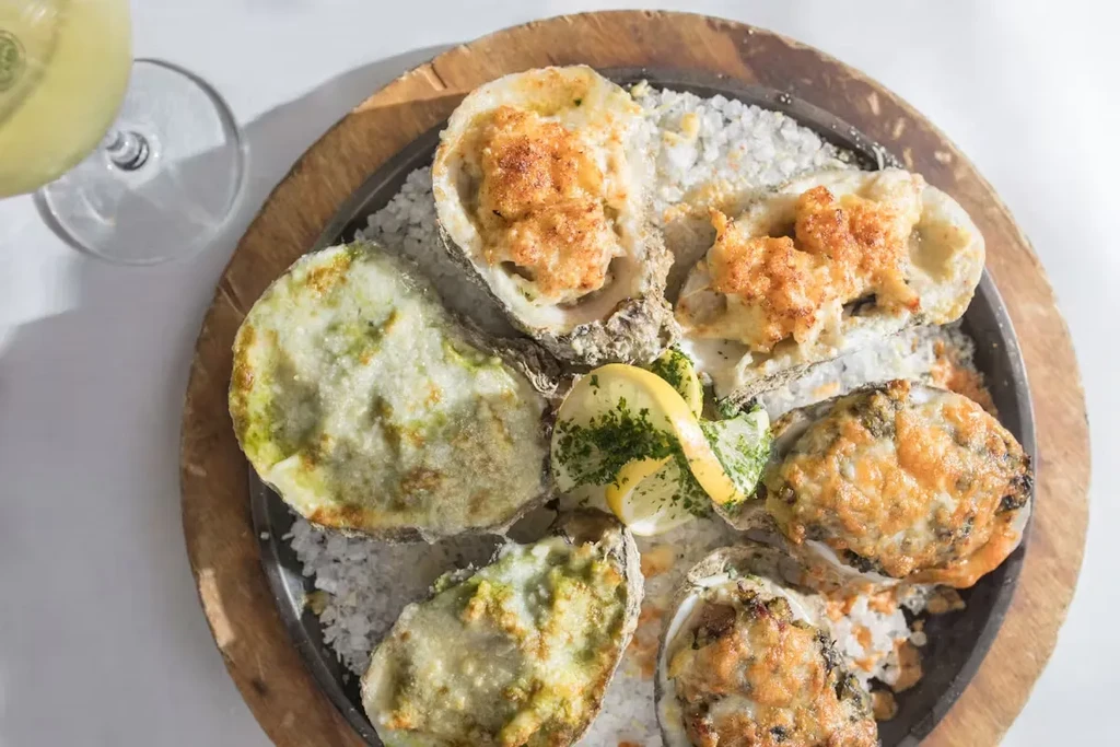 Overhead shot of a platter of baked oysters with various toppings.