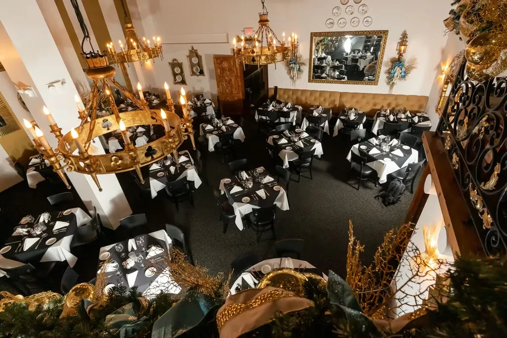 Overhead view of an elegant dining room with many tables and chandeliers.