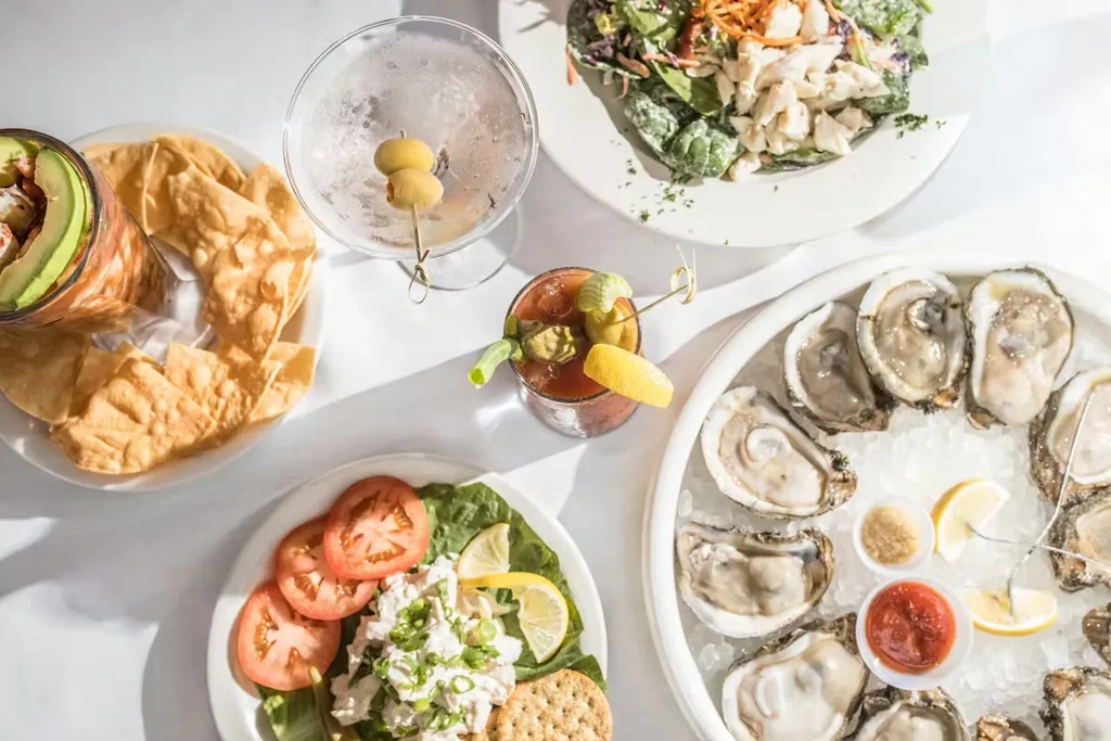 Overhead shot of a table laden with various seafood dishes and drinks.
