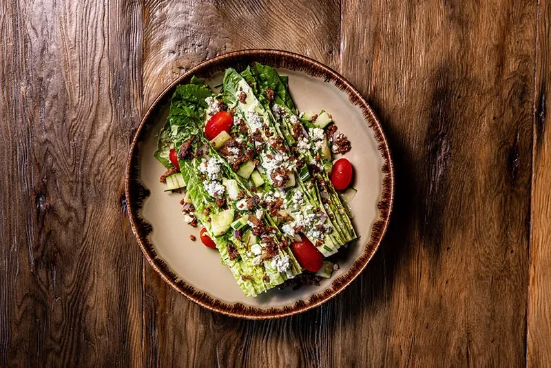 Overhead shot of a wedge salad with blue cheese and bacon.