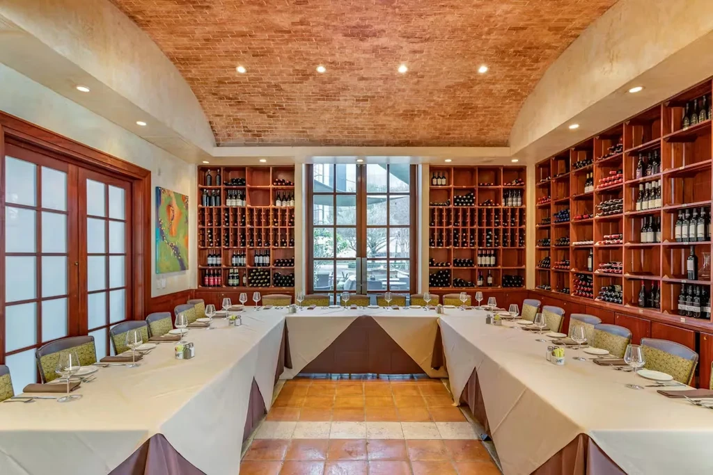 U-shaped private dining room with wine shelves and barrel-vaulted ceiling.