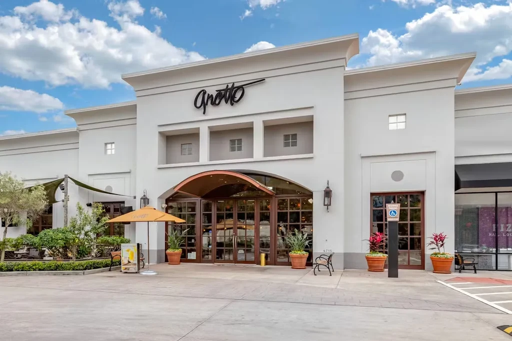 Exterior of Grotto restaurant with arched doors and outdoor patio.