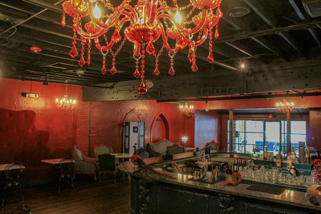 Luxurious restaurant interior with red chandelier, bar, and lounge seating.
