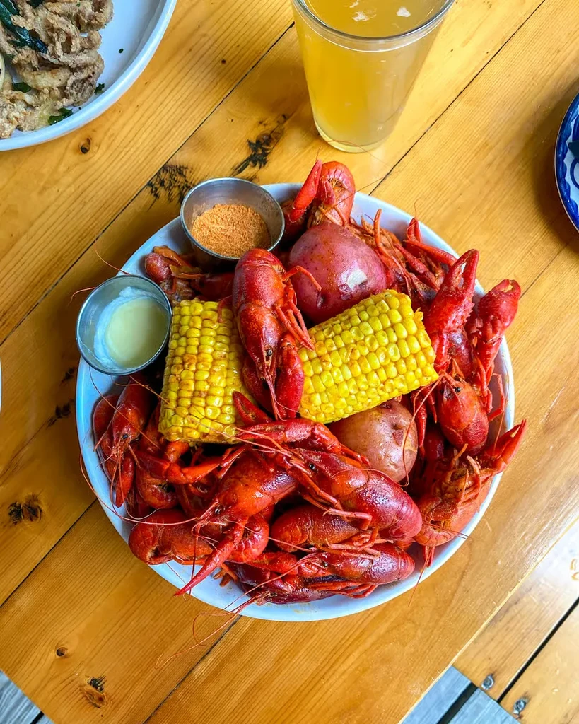 Overhead view of a crawfish boil in a white bowl.