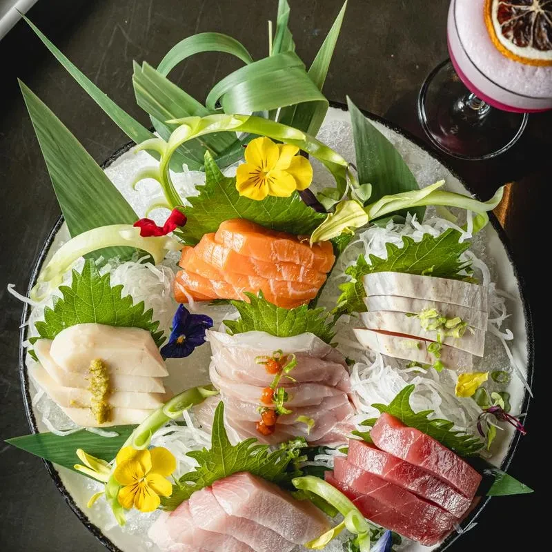 Sashimi platter with salmon, tuna, various fish, and garnishes.