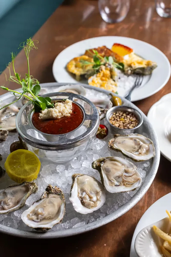 Raw oysters on the half shell with sauces on crushed ice.