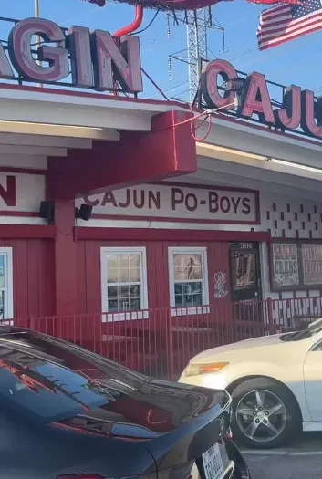 Exterior of red "Cajun Po-Boys" restaurant with American flag.
