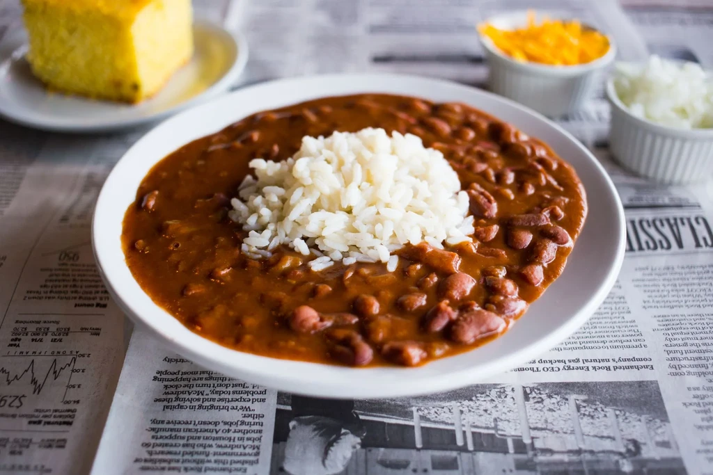 Overhead shot of red beans and rice, cornbread, cheese, and onions.