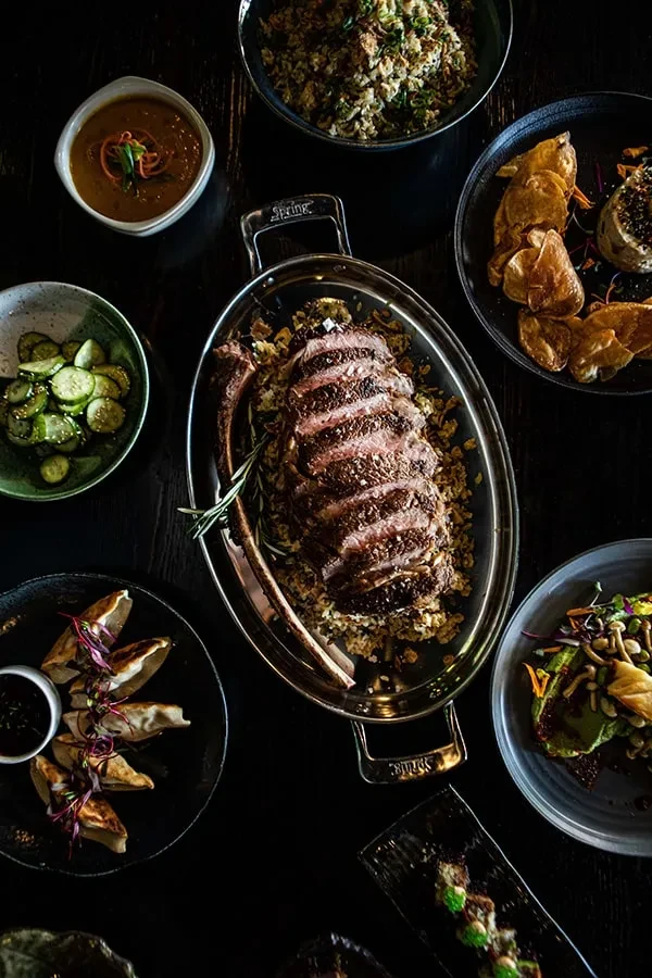 Overhead shot of prime rib, fried rice, dumplings, and other dishes.
