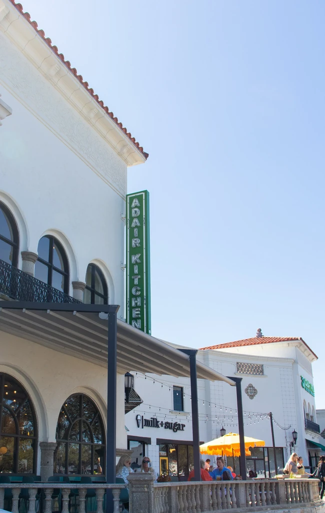 Exterior of Adair Kitchen restaurant with patio seating on a sunny day.
