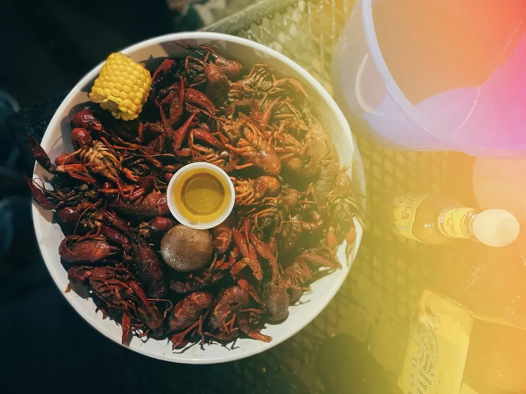 Top-down view of cooked crawfish in a bowl with corn and sauce.