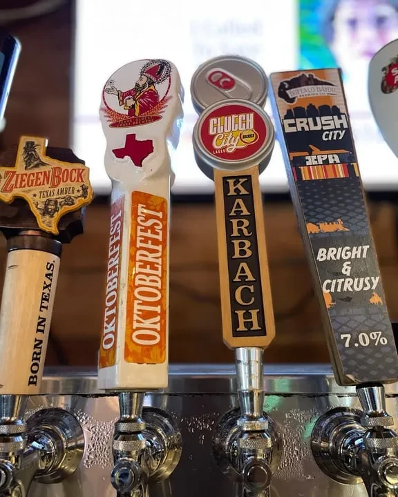 Close-up of four beer tap handles in a bar.