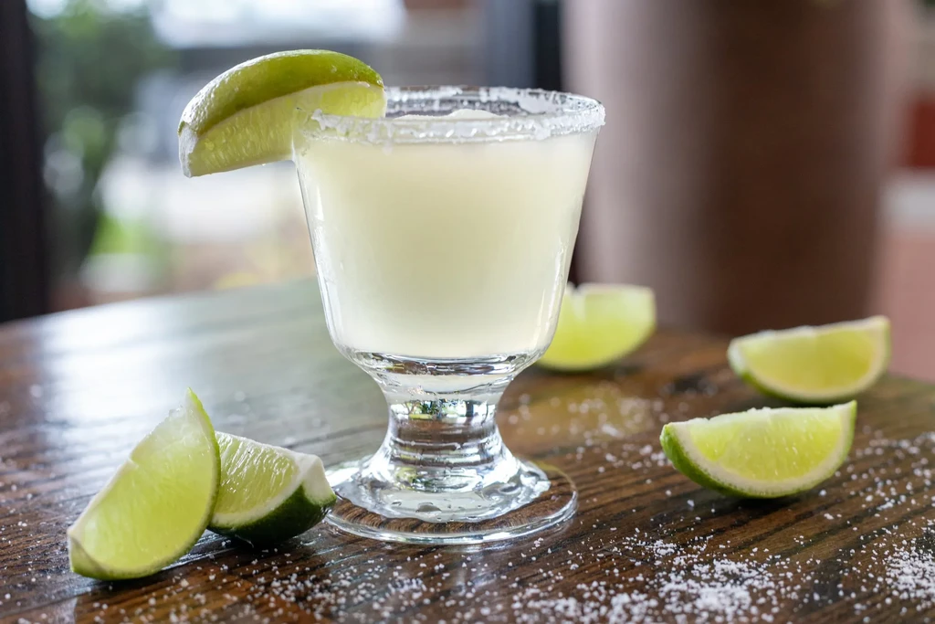 Margarita in a stemmed glass with salt rim and lime wedge.