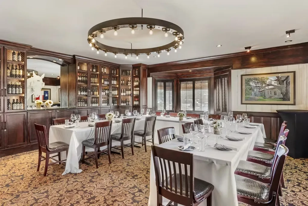 Elegant private dining room with multiple tables and a wine cellar.