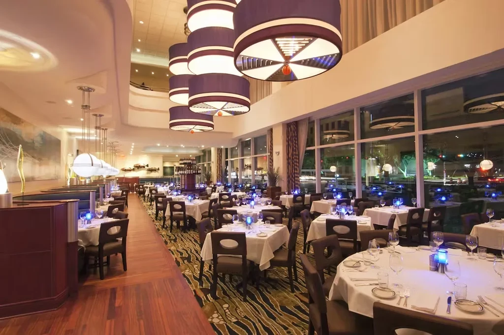 Upscale restaurant dining area with tables set and modern lighting.