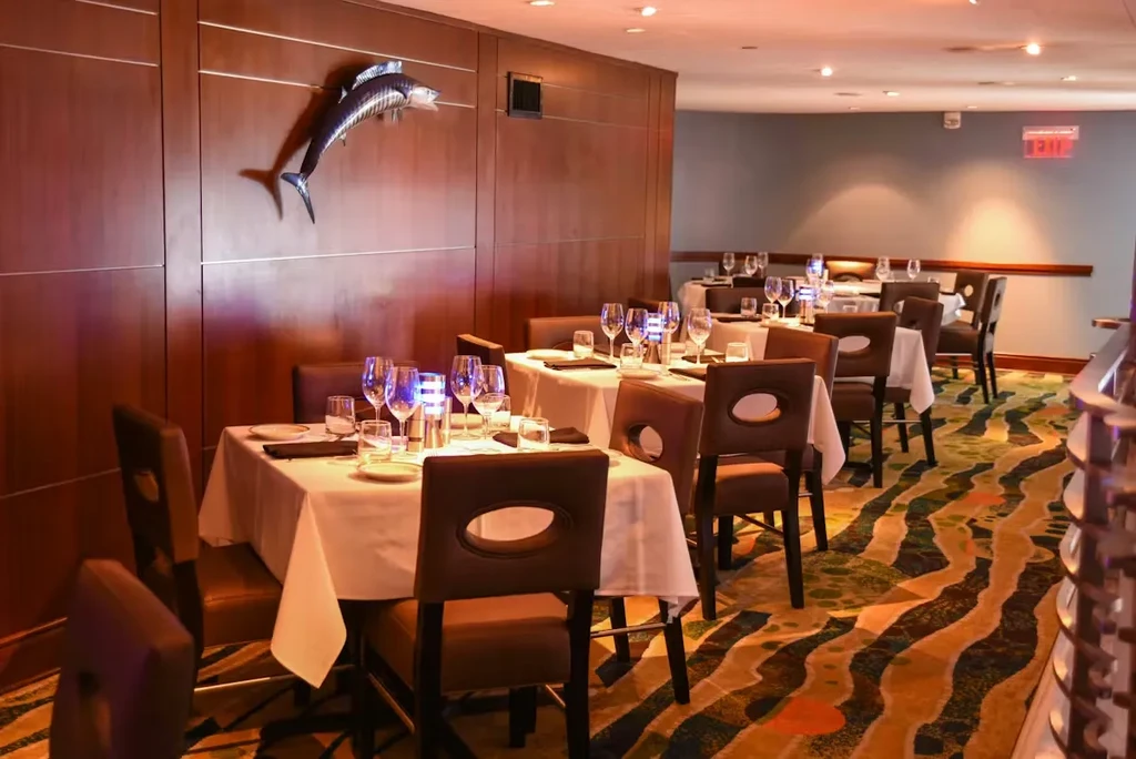 Sophisticated restaurant dining area with set tables and a fish sculpture.