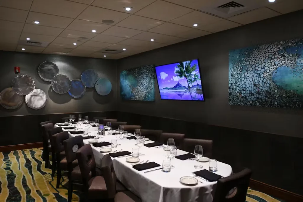 Set dining table in a private room with art and a TV.