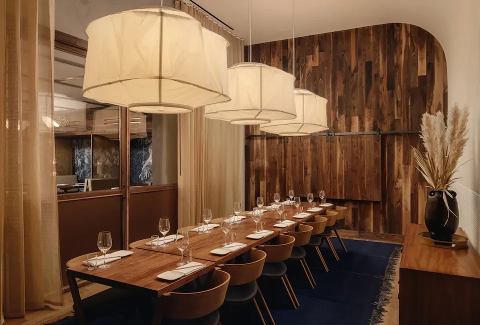 Well-appointed private dining room with a long wooden table and chairs.