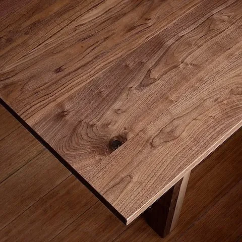 High-angle close-up of a wooden tabletop with visible grain and knot.