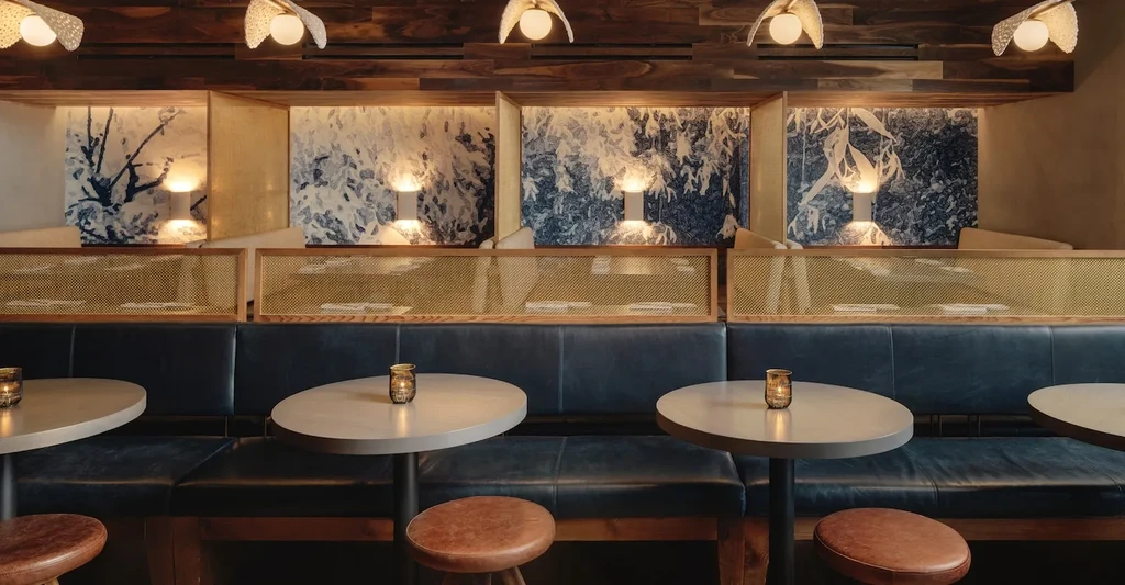 Stylish restaurant interior with booth seating, tables, and warm lighting.
