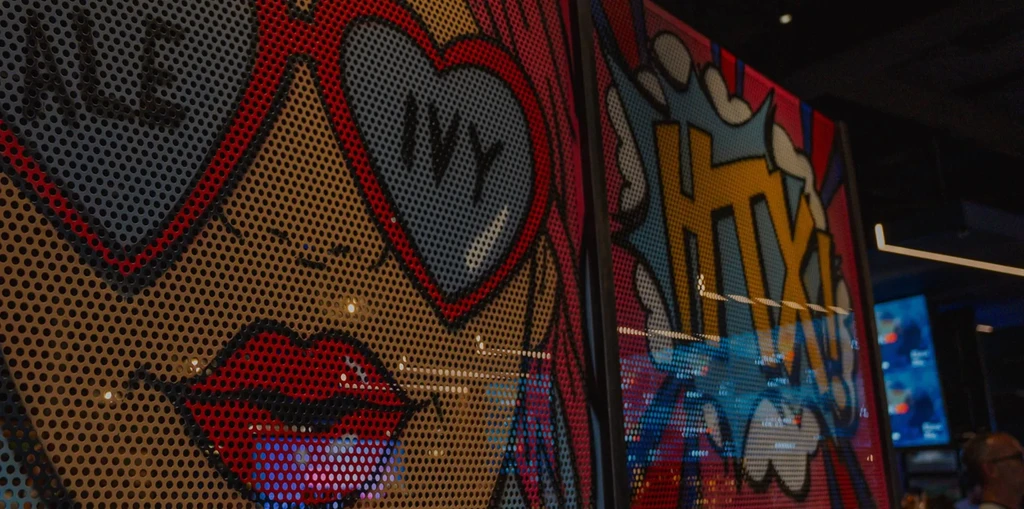 Pop-art woman with "IVY" on heart sunglasses in a restaurant.