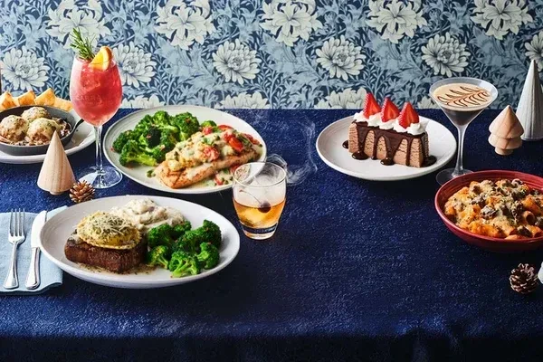 A festive table laden with gourmet food, cocktails, and holiday decorations.