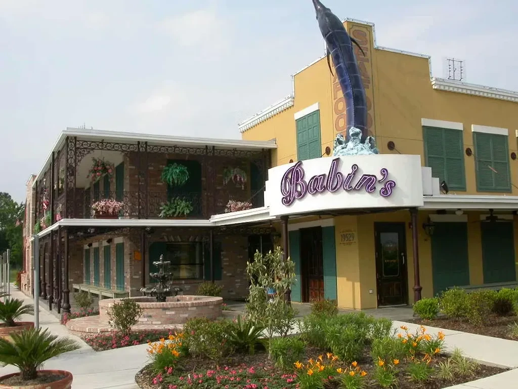 Babin's restaurant exterior with French Quarter style, fountain, and marlin sculpture.