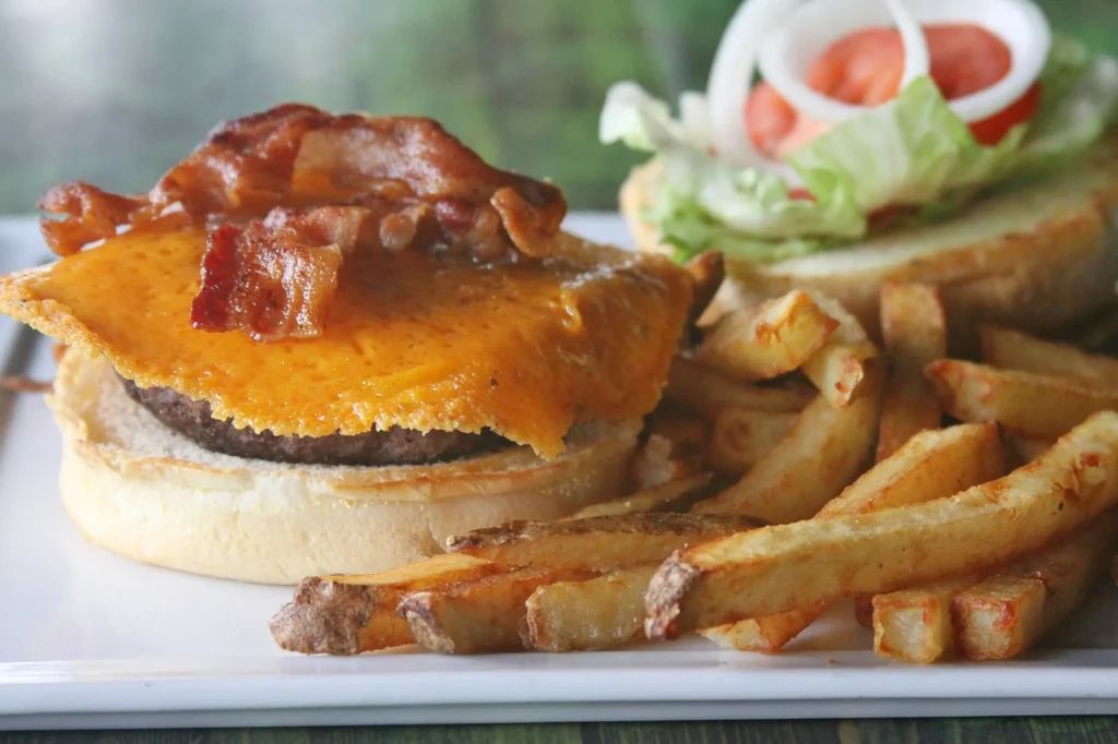 Gourmet bacon cheeseburger, french fries, lettuce, tomato, and onion.