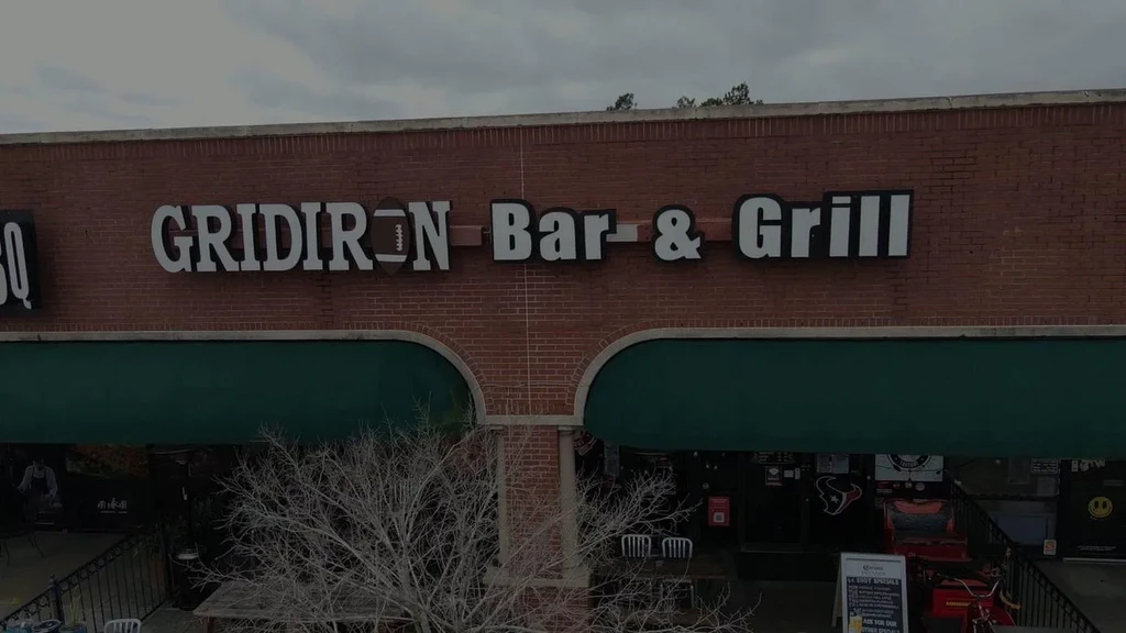 Red brick building with "GRIDIRON Bar & Grill" sign.