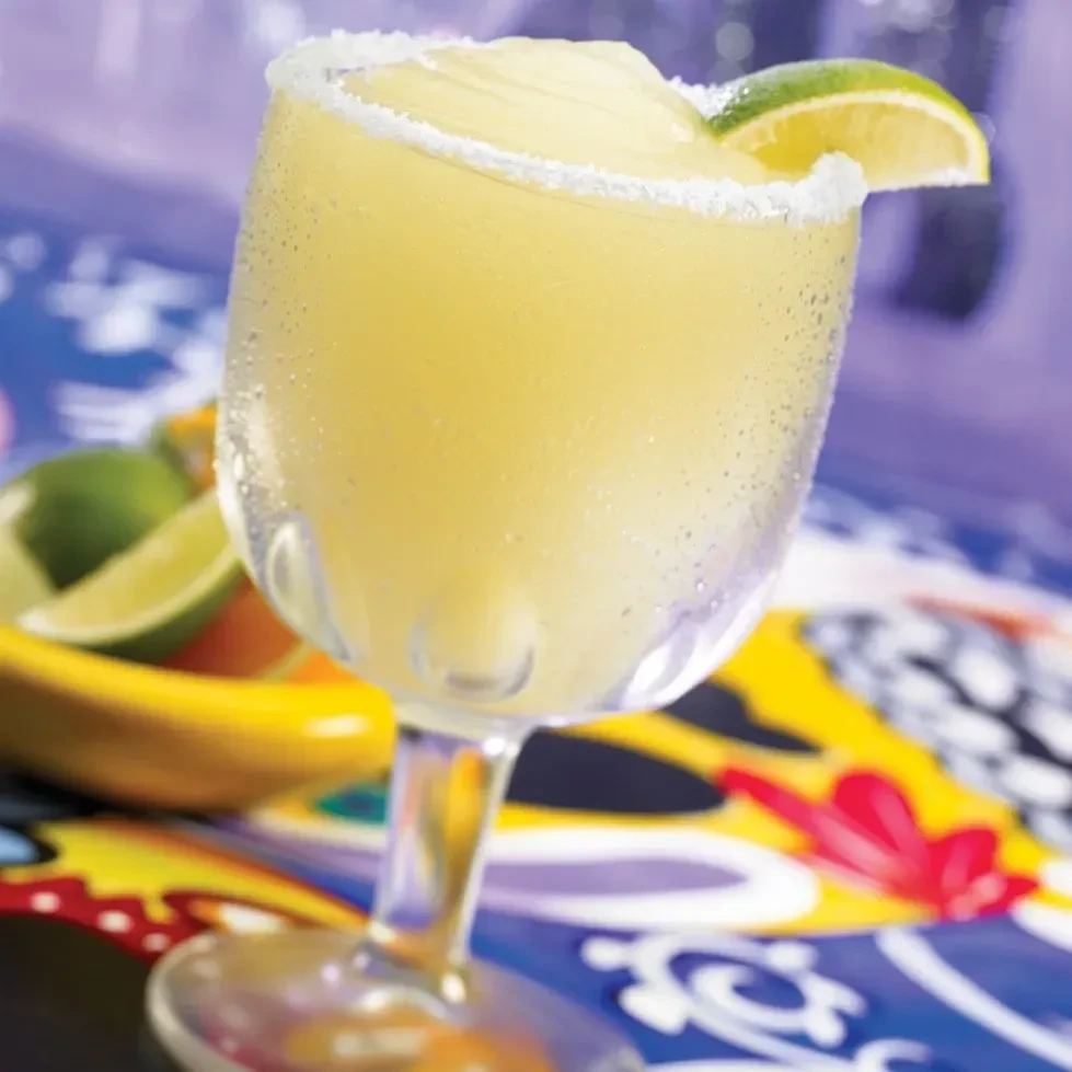 Close-up of a frosty pale yellow drink with a salted rim.