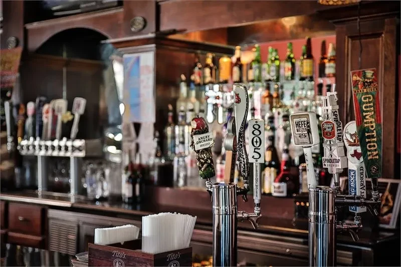 Beer taps and liquor bottles behind a dark wood bar.