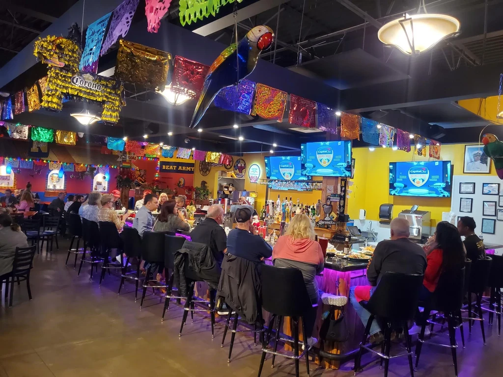 Restaurant interior with colorful Mexican decorations and patrons dining.