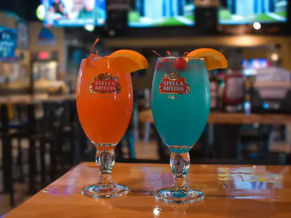 Colorful Stella Artois cocktails in a lively bar setting.