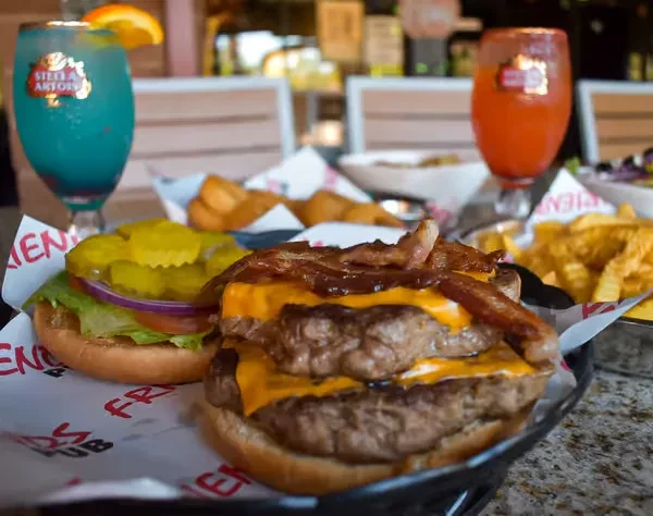 Two substantial burgers with fries and drinks at Friends Pub.