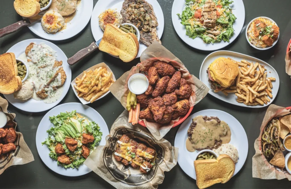 Table completely covered with a variety of casual restaurant comfort foods.