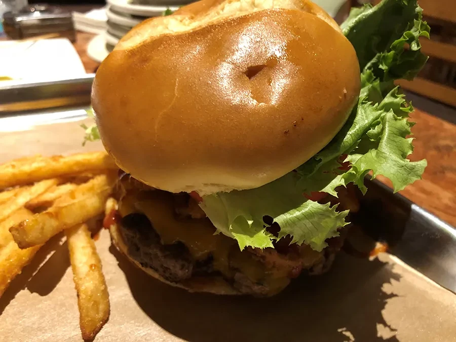 Large burger with multiple patties, melted cheese, and golden fries.