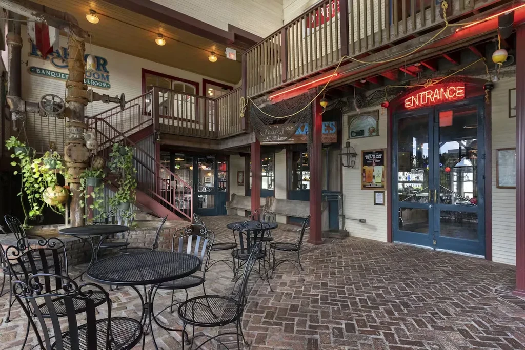 Rustic multi-level restaurant patio with tables, chairs, and industrial decor.