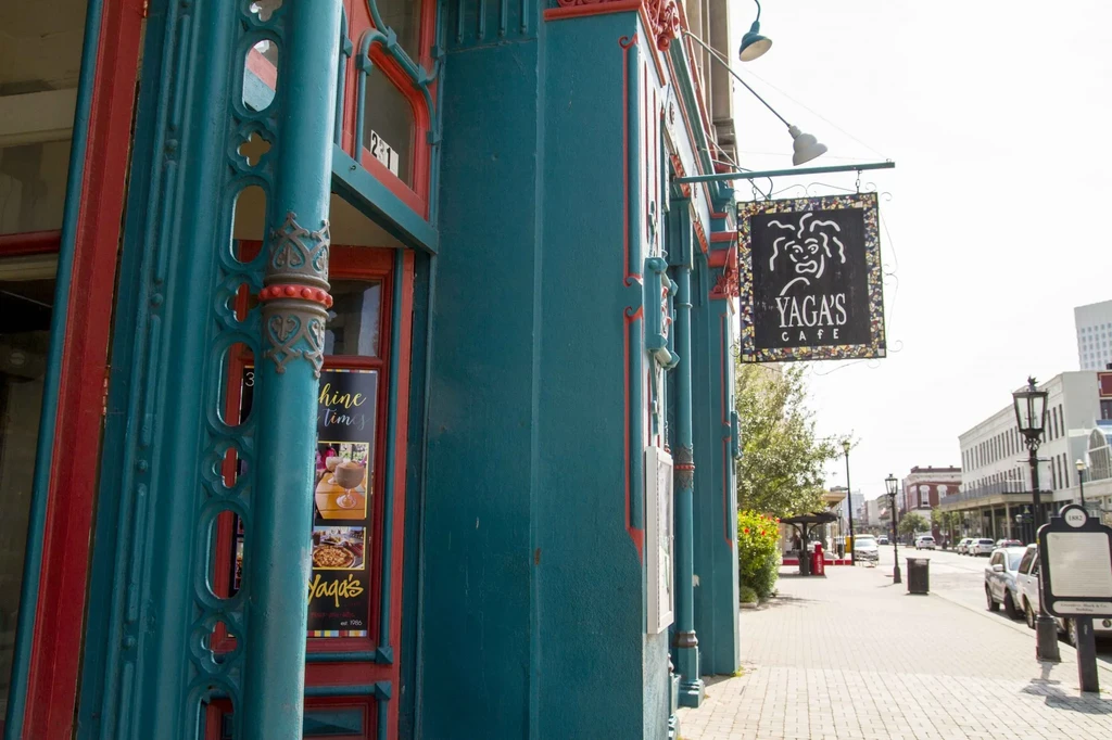 Teal Yaga's Cafe building with red trim on a sunny street.