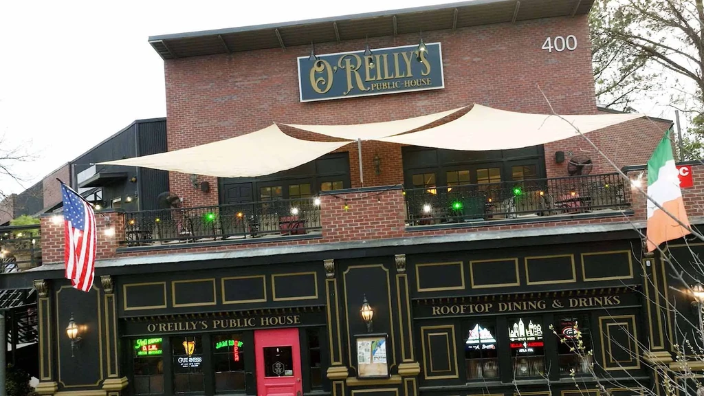 Exterior of O'Reilly's Public House with rooftop dining and flags.