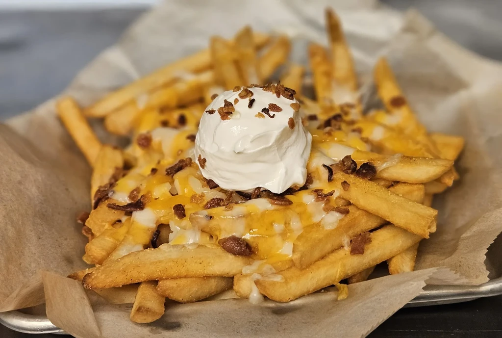 Loaded french fries with melted cheese, sour cream, and bacon bits.