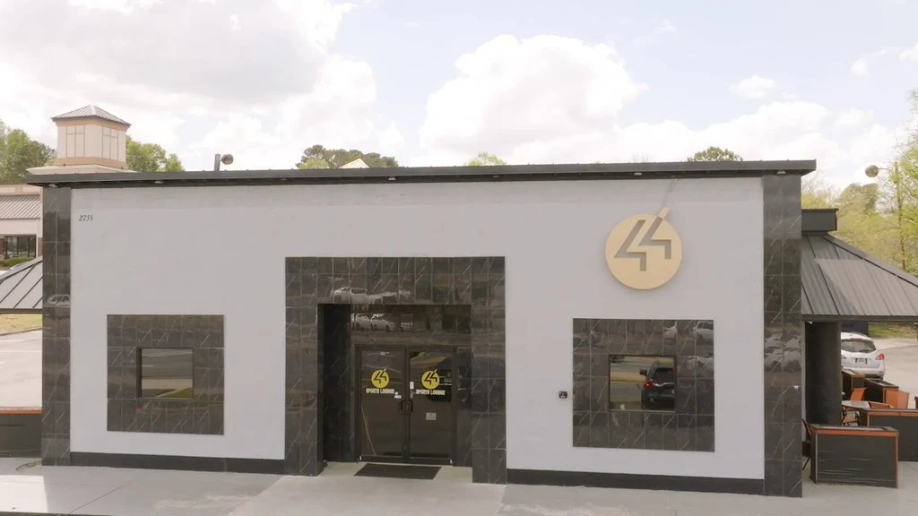 Modern grey 44 Sports Lounge exterior with prominent '44' logo and patio.